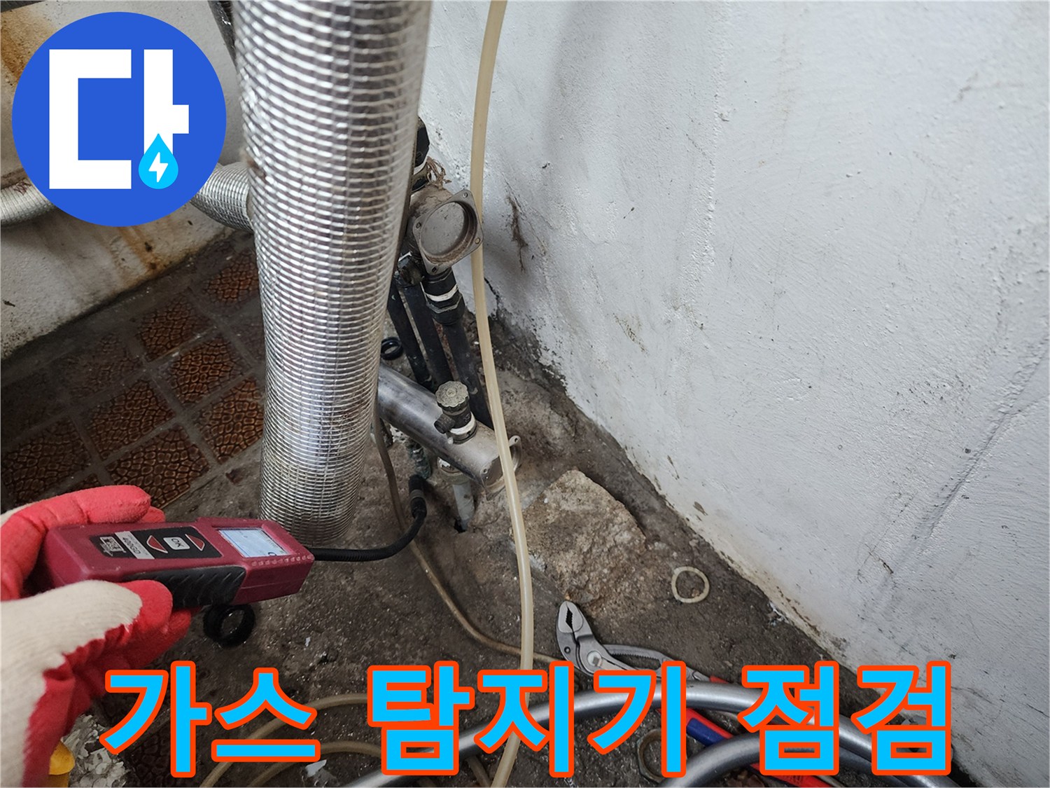 보일러실 배관 부근에서 가스 탐지기로 누수 지점을 찾는 모습