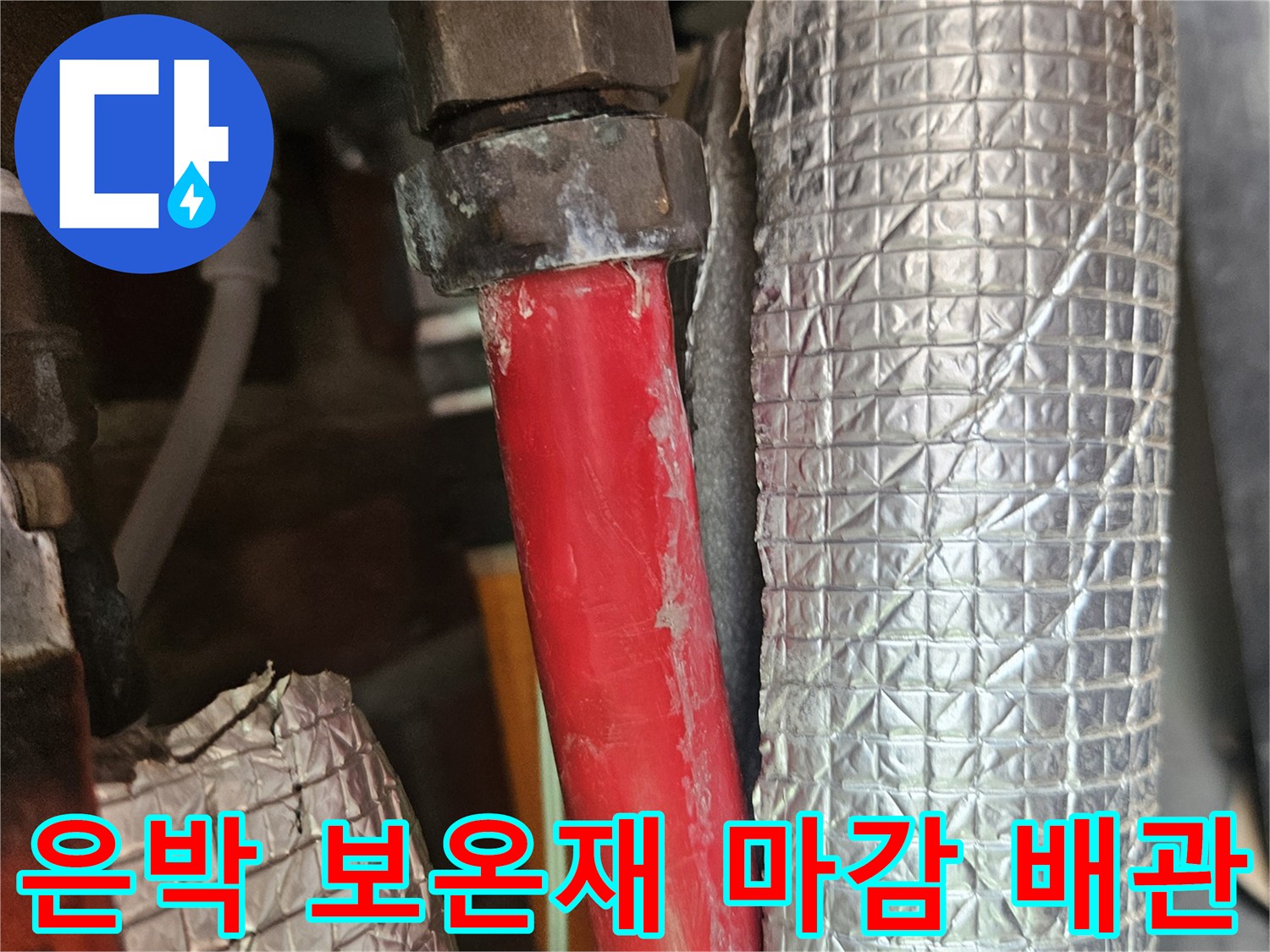 보일러실 내부 은박 보온재 배관과 빨간색 온수 라인 접합부