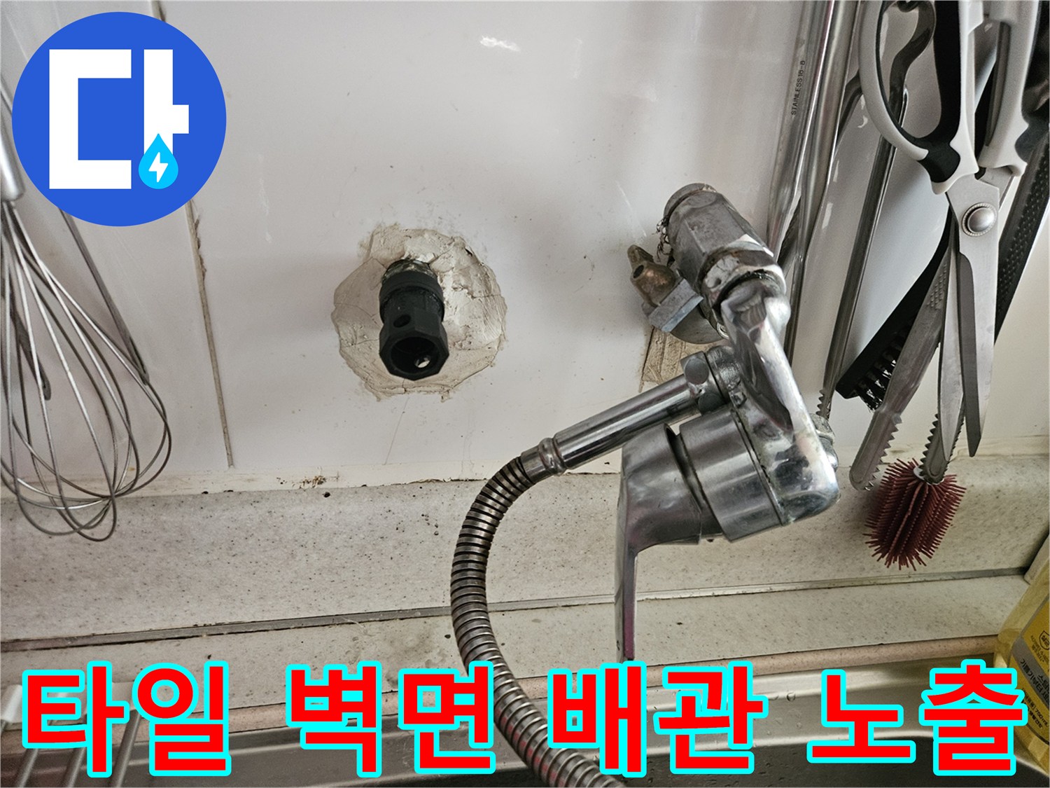 하얀 타일 사이 검은색 배관 돌출부와 금속 주방 호스 연결 부위