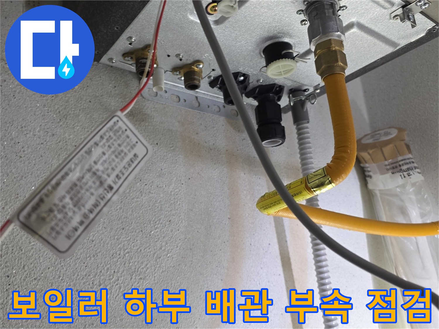 보일러 아래쪽-노란색 배관과 금속 부품의 연결 상태를 보여줍니다.