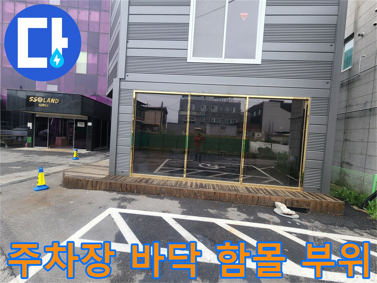 건물 외곽 주차장 아스팔트 면의 균열과 침하된 구역