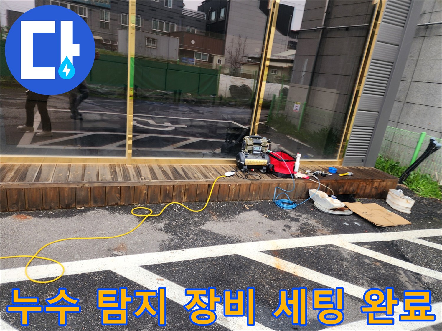 아스팔트 작업 구역에 놓인 전동식 누수 진단 장비와 공구함