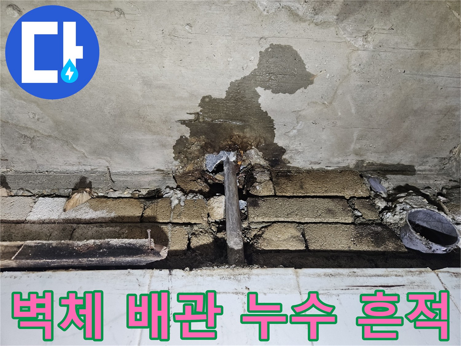 콘크리트 벽면에 나타난 습기 얼룩과 노출된 배관 부위