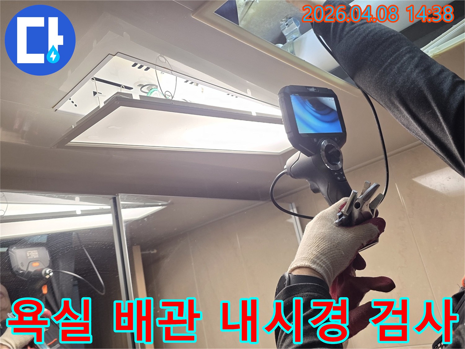 누수 전문 기술자가 내시경 카메라로 욕실 천장 내부의 배관을 정밀하게 검사하며-숨겨진 누수 원인을 찾아내고 있습니다.