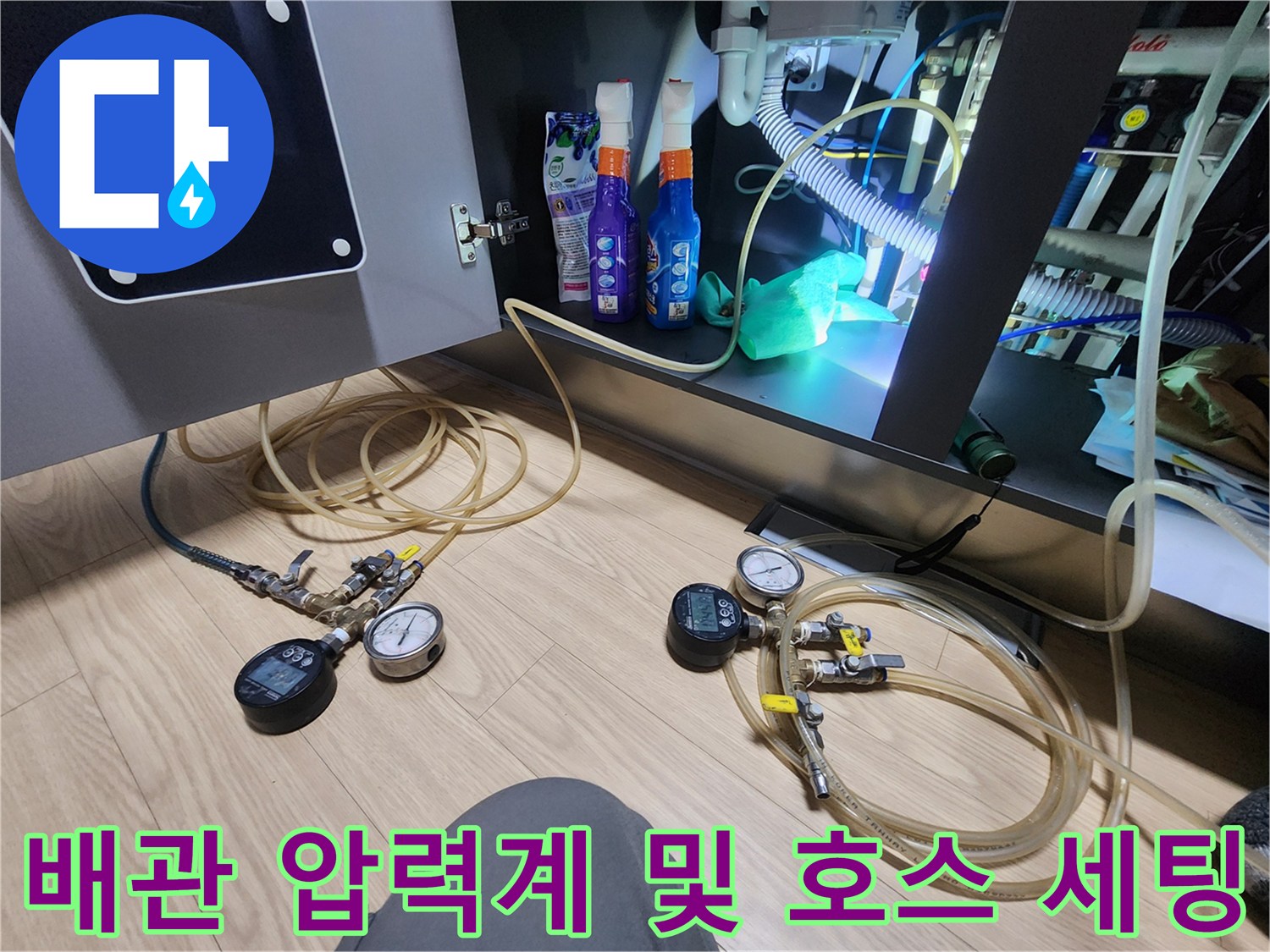 싱크대 하단 점검-누수 확인을 위해 설치된 배관용 압력 게이지와 호스