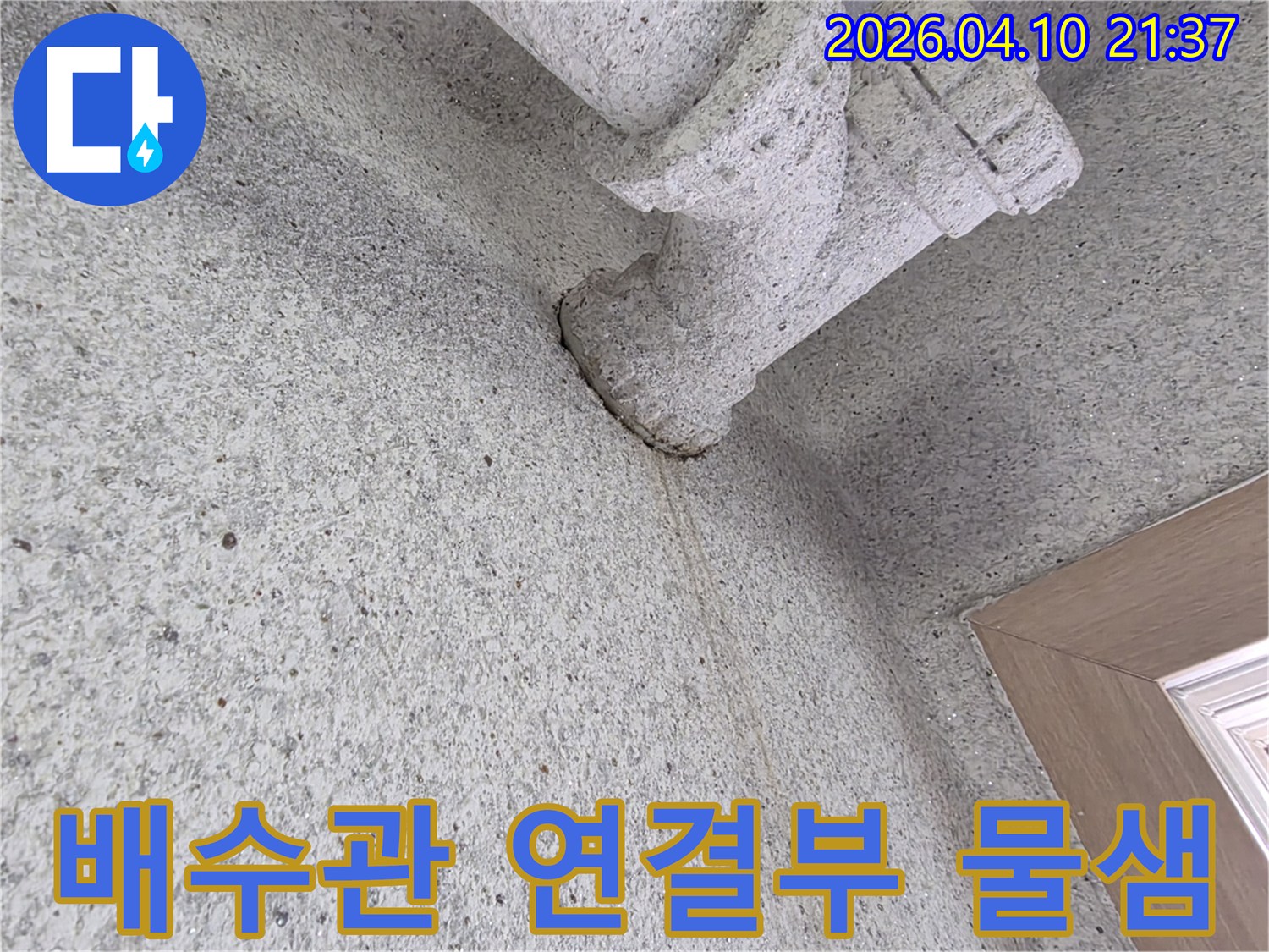 콘크리트 벽에 설치된 배수관 연결부에서-물이 흘러내린 자국이-뚜렷하게 보이는 현장 사진입니다