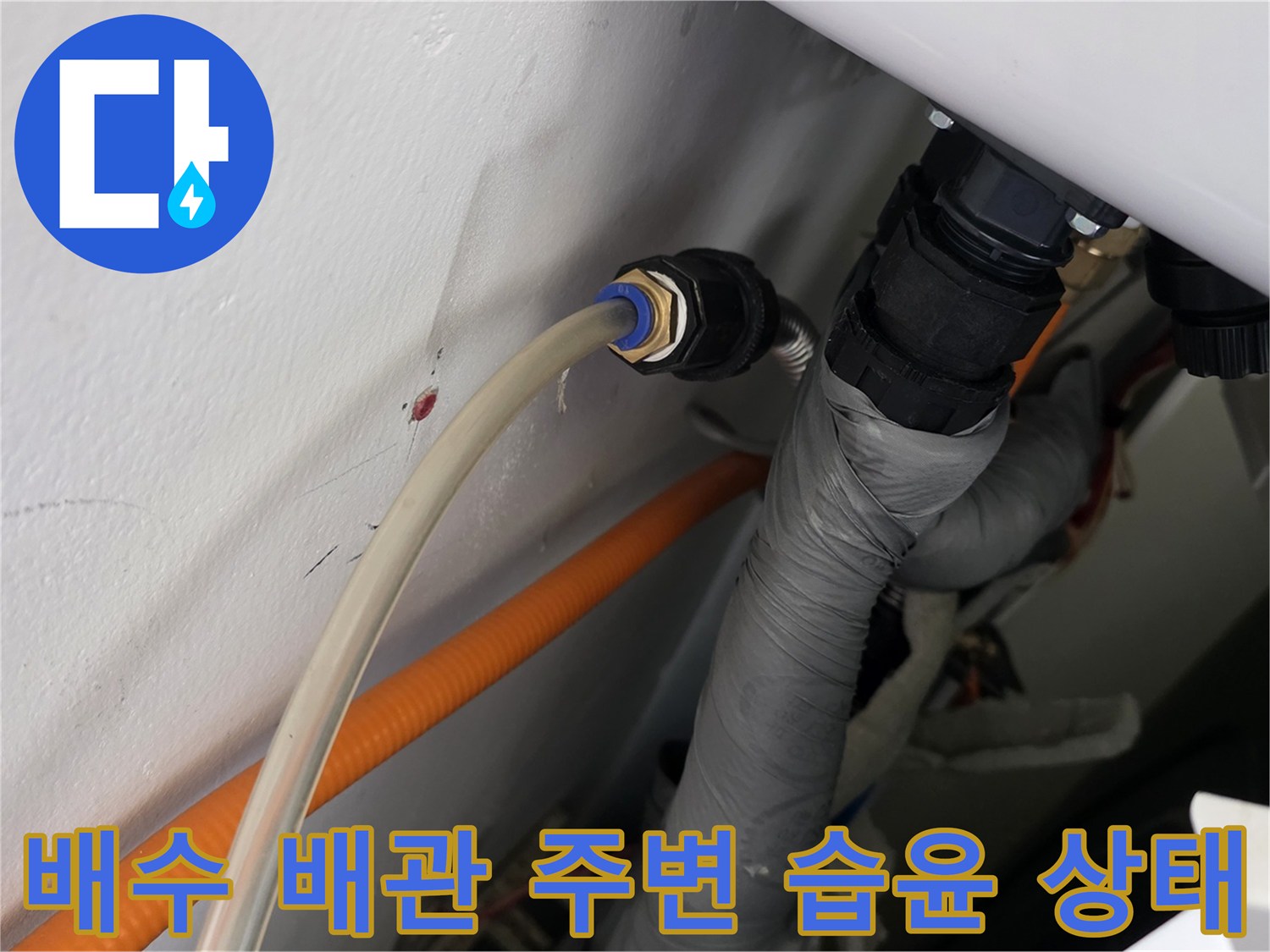 배수 파이프 연결부와 벽면의 접촉 지점을 촬영한 사진입니다.