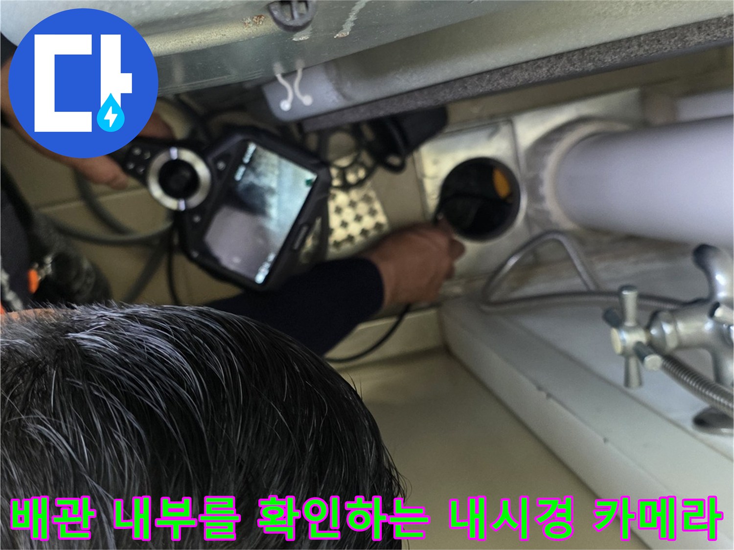 배수관 내부 상태를 점검하기 위해 내시경 장비를 투입하고 화면을 모니터링하는 장면입니다.