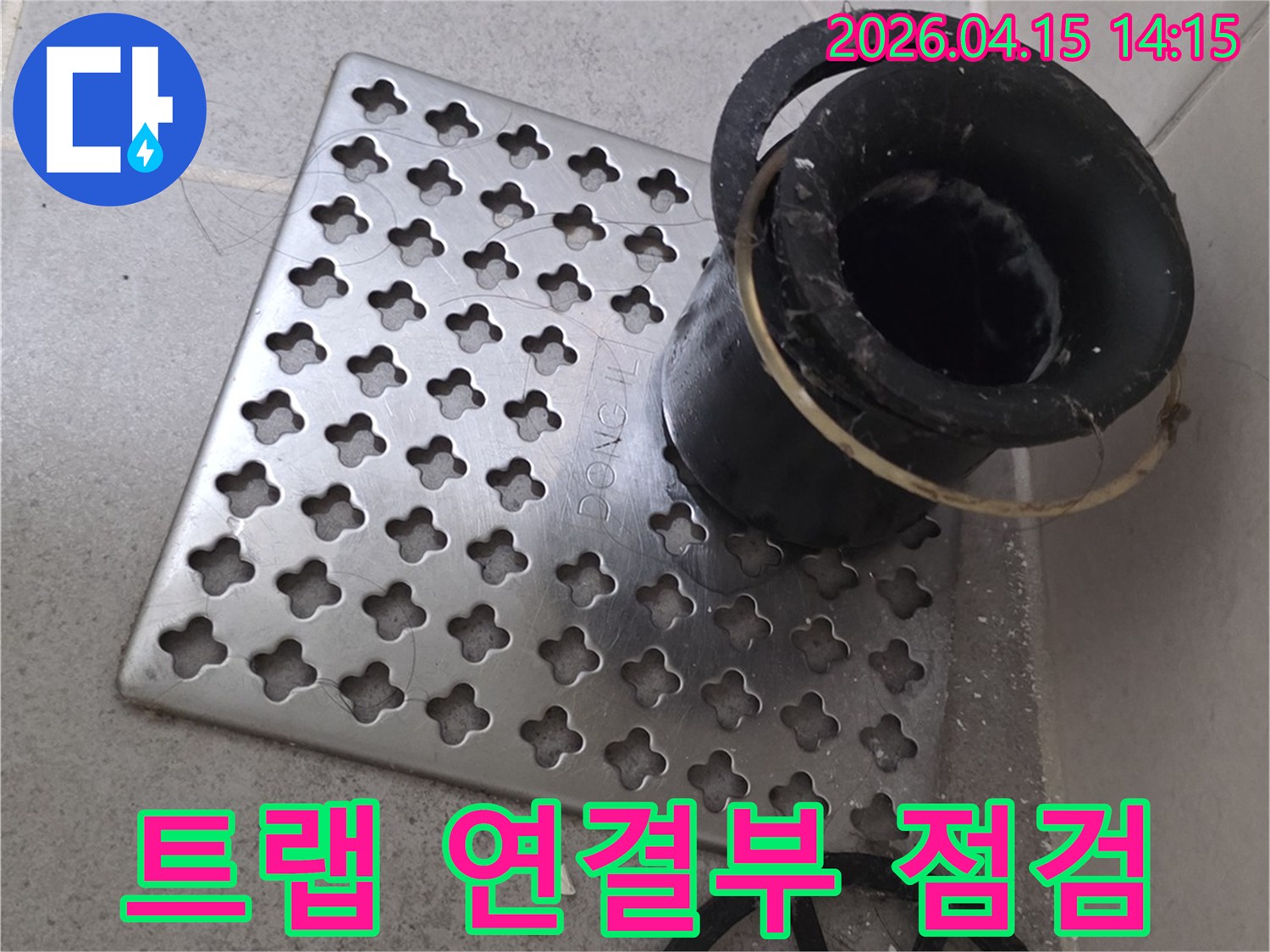 욕실 배수구의-트랩과 배관의 연결 부위를-자세히 점검하는 모습으로-누수 지점을 찾아내고 있습니다.