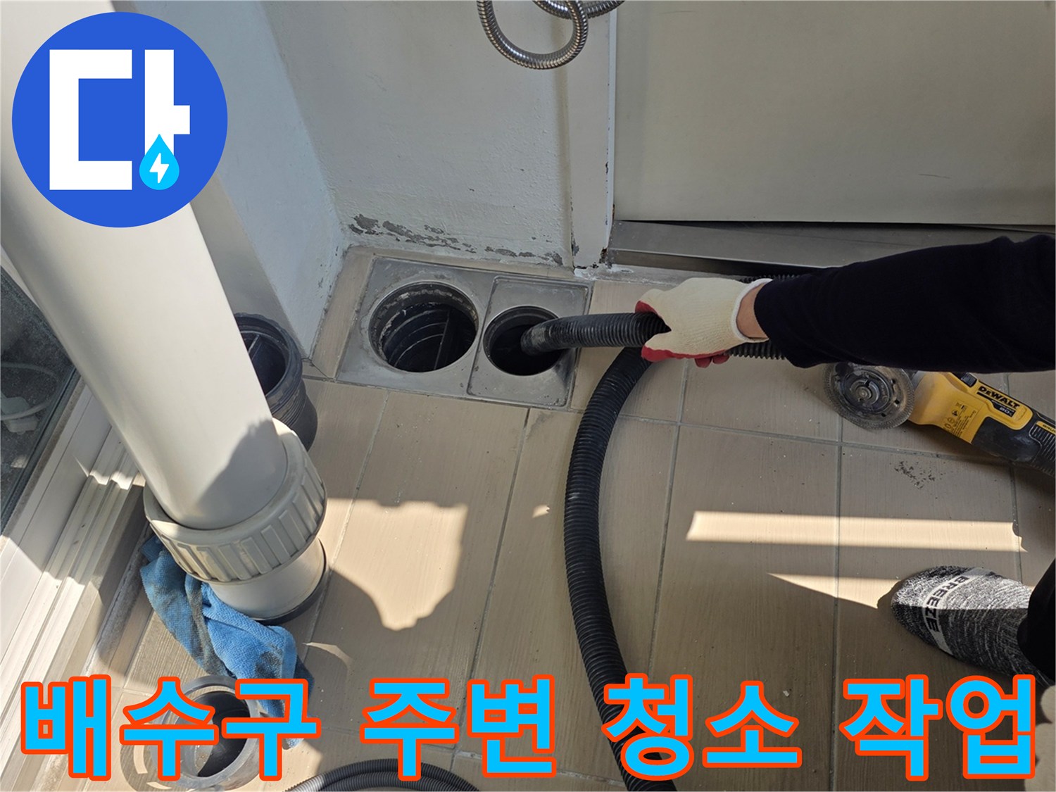 진공청소기로 배수구 틈새의 먼지를 흡입하는 엔지니어의 모습