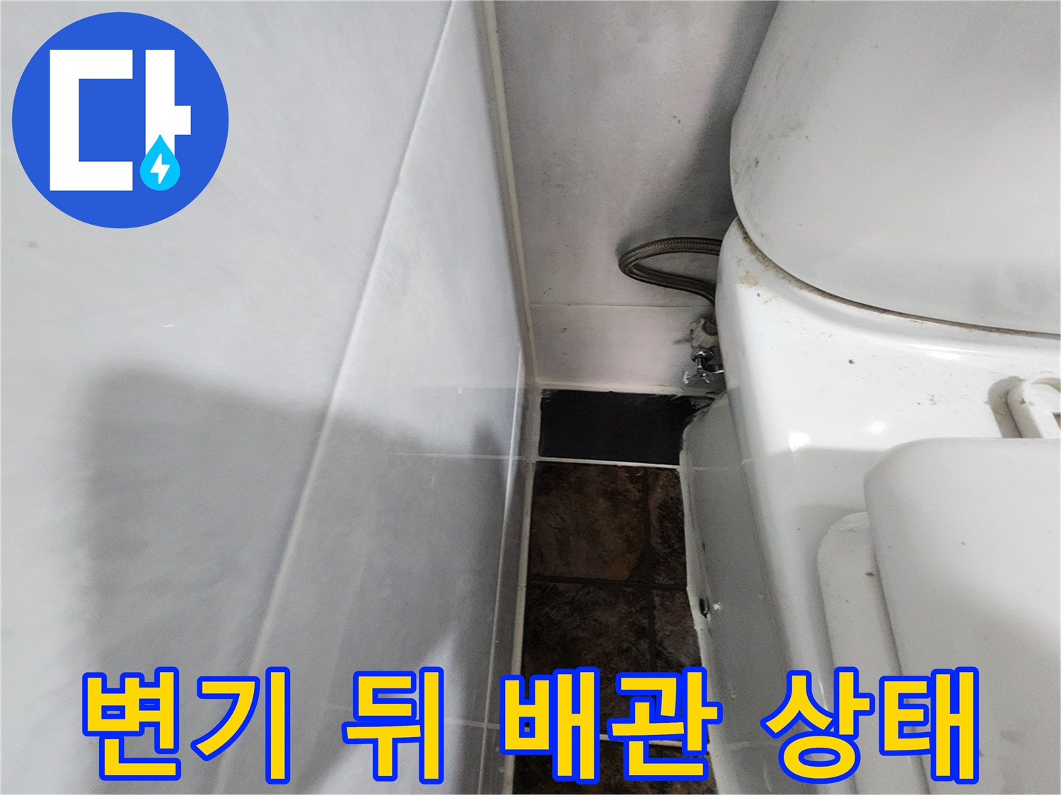화장실 변기 뒤편에 위치한 급수 배관과 벽면 타일 모습