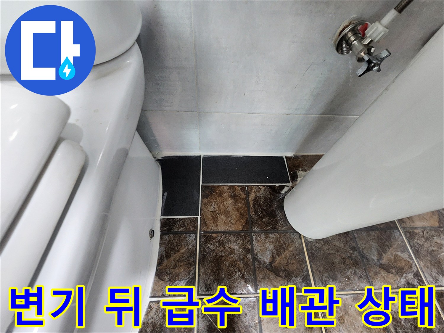 화장실 변기 뒤편에 위치한 급수 밸브와 연결 배관의 모습입니다.