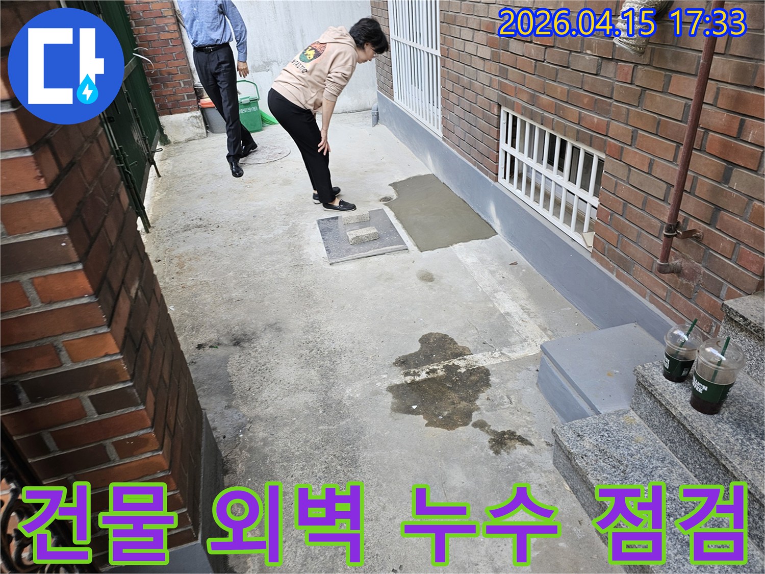 성동구 장터1가길-주택 외벽과 인접한-지하 공간의 누수-현장을 전문가가-확인하는 모습