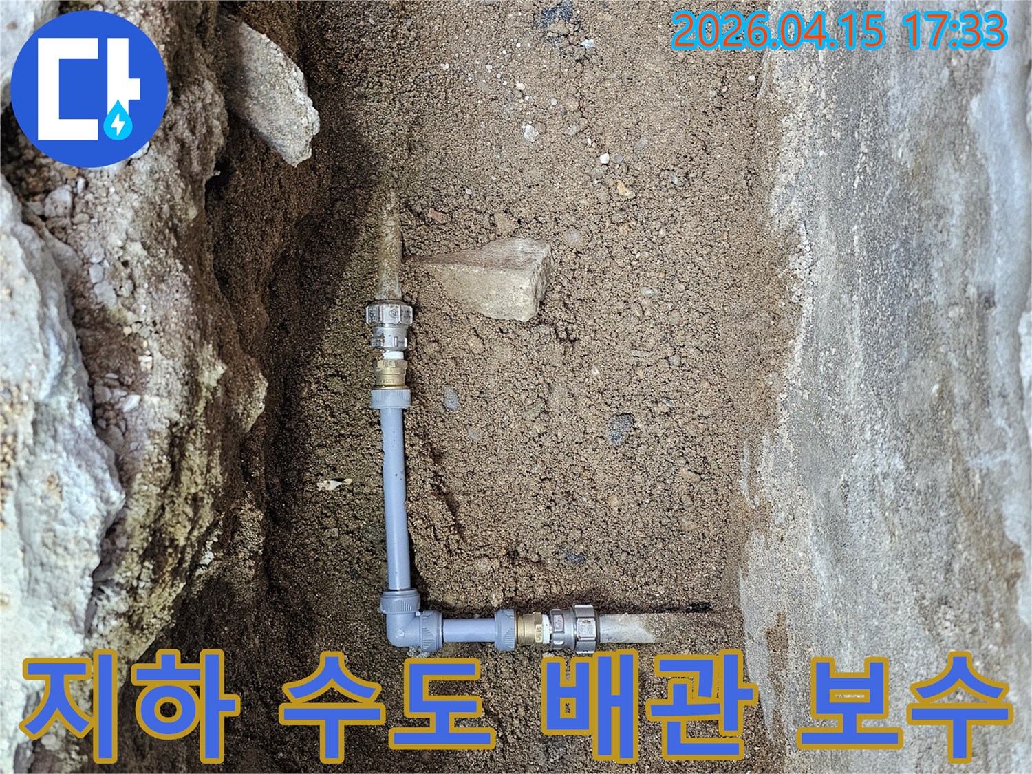 이 사진은 지하에 매설된-수도 배관에서 발생한 누수를 수리하기 위해-새로운 배관을 연결하는 전문적인 작업 현장입니다.