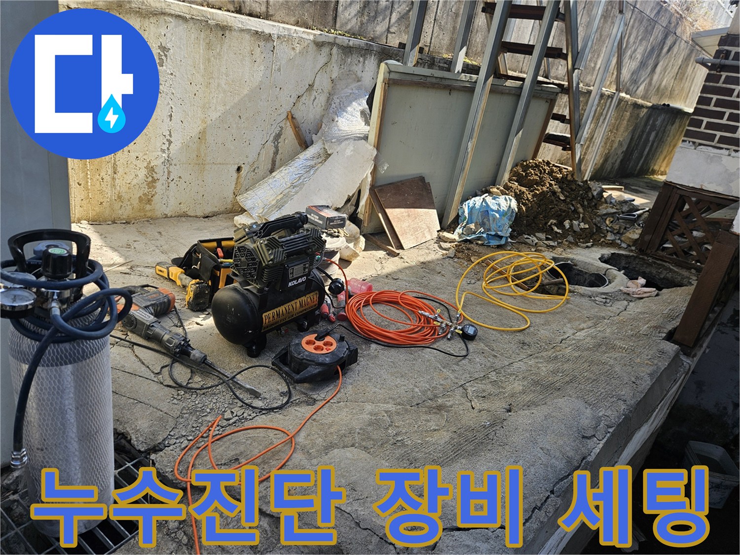 누수 공사 현장에서-정확한 진단을 위해-에어 콤프레셔-함마드릴-호스-전선릴 등-다양한 전문 장비들이-콘크리트 바닥 위에-준비되어 있는 모습