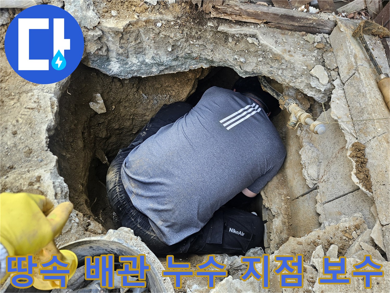 숙련된 누수 엔지니어가-땅속에 매설된 배관의-누수 지점을 보수하기 위해-좁은 구덩이에서 작업하는 모습