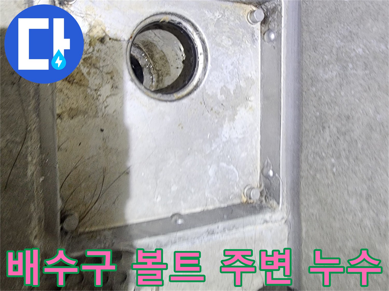 욕실 배수구의 고정 볼트 주변에서-발견된 물때와-오염 상태를-면밀히 관찰하며-누수 원인을-추정하는 장면입니다