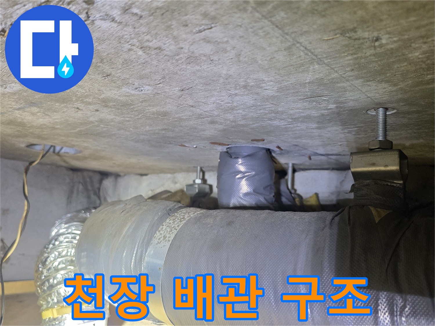 아파트 천장 내부의 보온재로 감싸진 배관과 고정 장치 모습