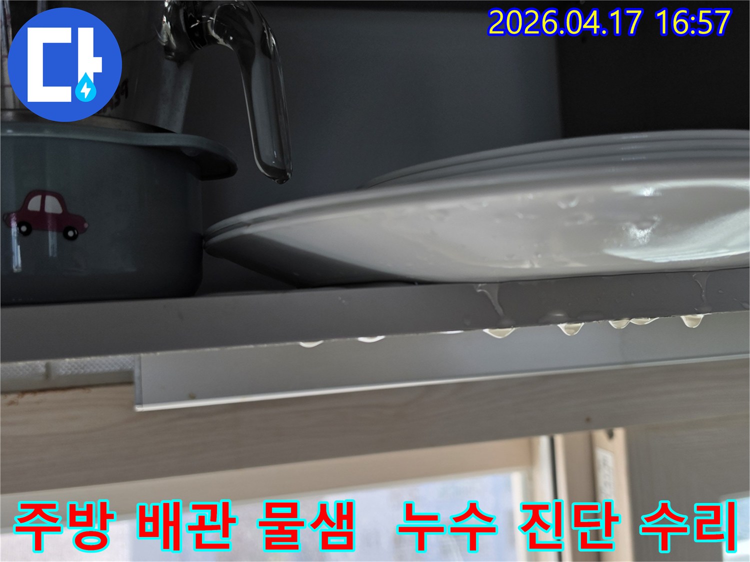 경기 용인시 기흥구 효성해링턴플레이스 주방 싱크대 선반에서 물이 새는 현장을 보여주며-배관 누수 진단 및 수리가 필요한 이미지입니다.