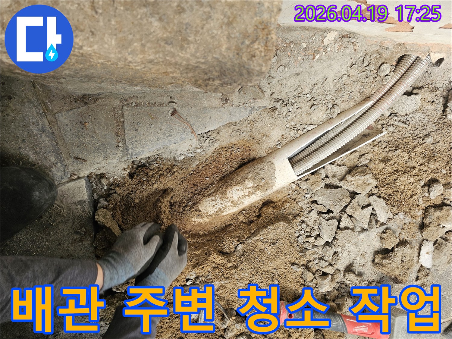 누수-수리를-위해-배관-주변의-흙과-이물질을-청소하는-작업자의-모습