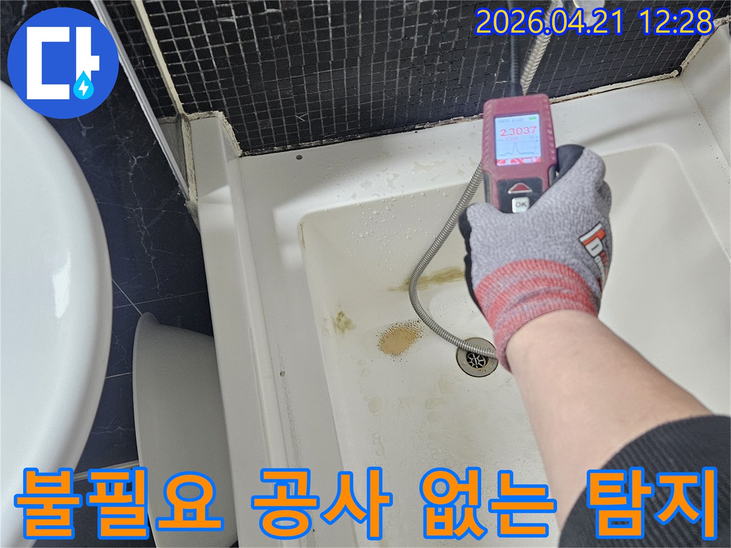 전문 엔지니어가 욕실 배수구 근처에서-누수 여부를 확인하기 위해-측정 장비를 사용하여 점검하는 모습입니다.