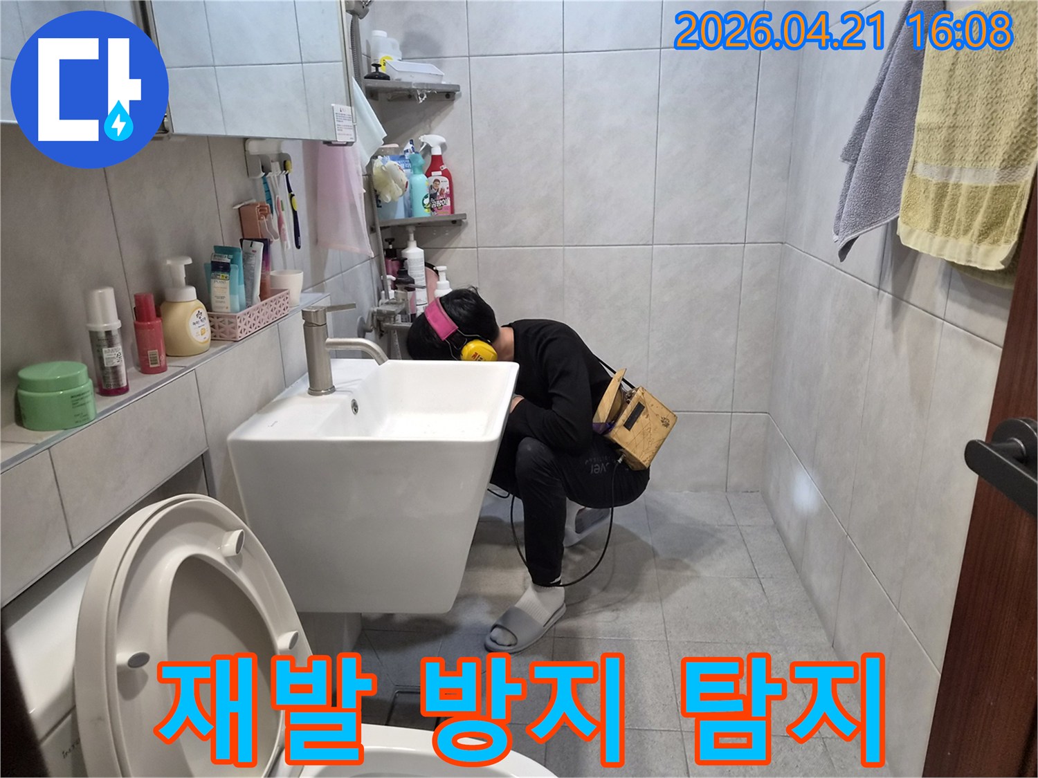전문 엔지니어가 욕실에서-청음 장비를 이용해-배관의 미세한 누수음을 듣고-재발 방지를 위해 정확한 누수 지점을 찾아내고 있습니다