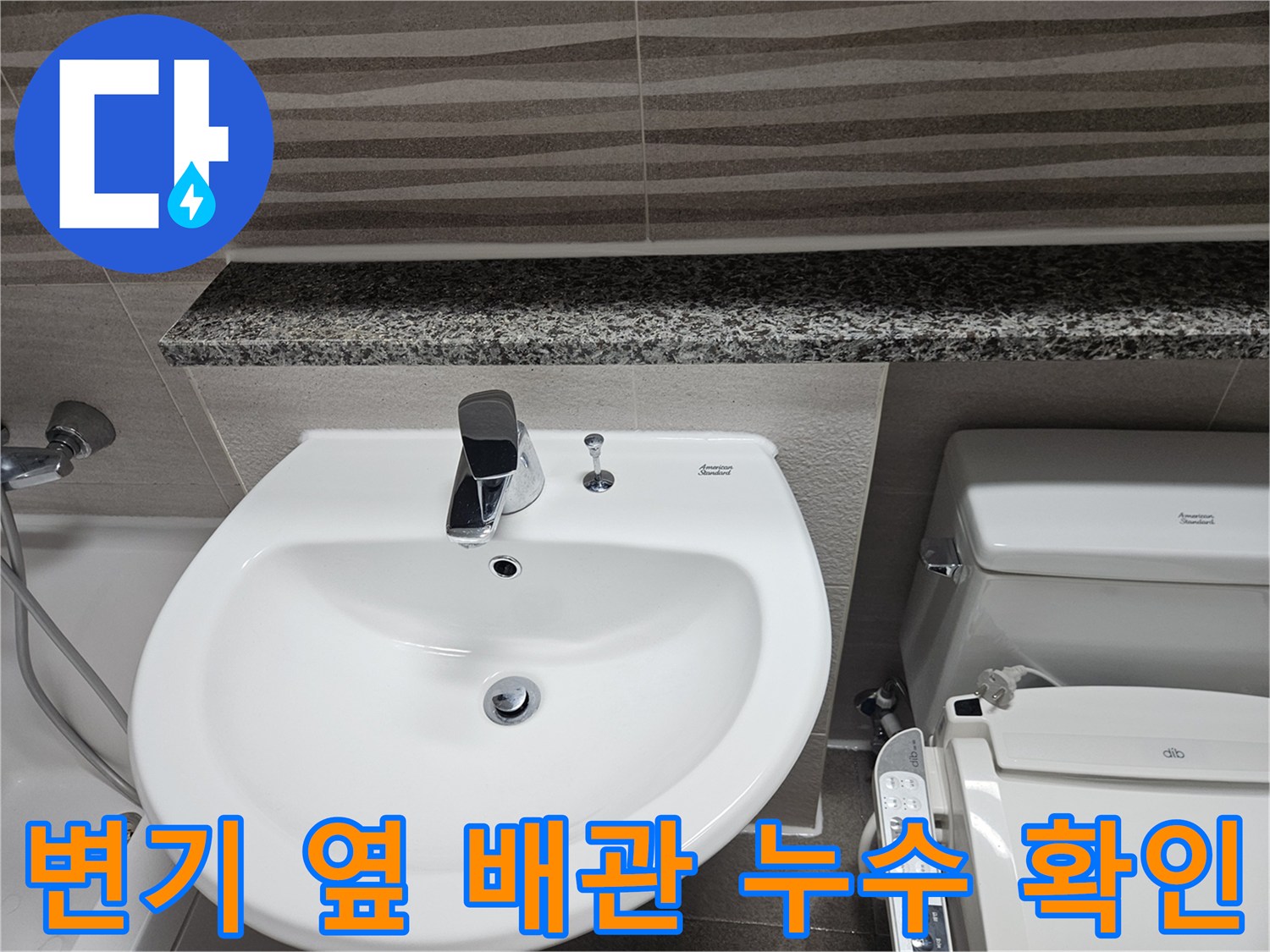 변기와-세면대-사이의-좁은-공간에-위치한-배관-연결부를-점검하는-장면입니다