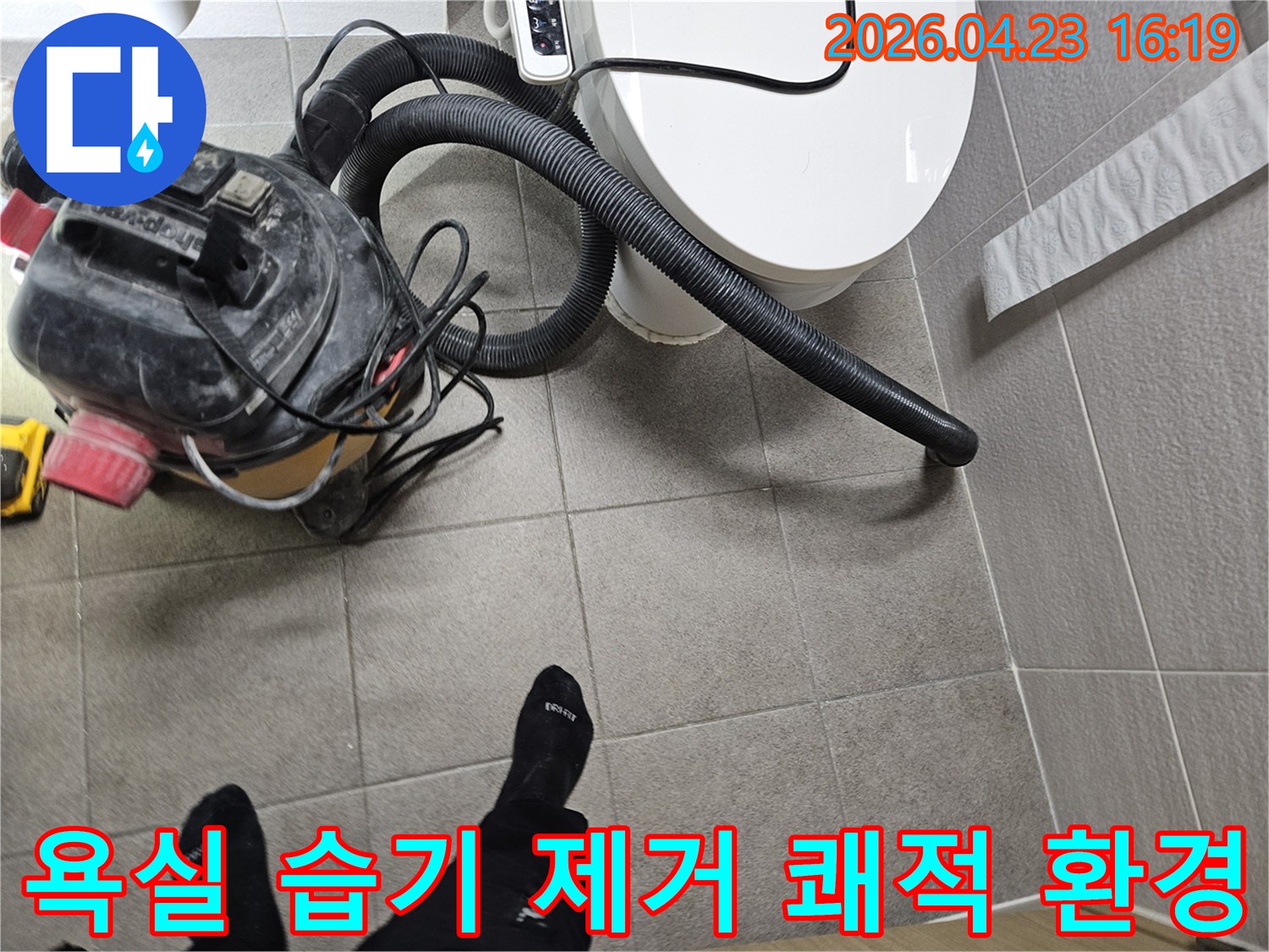 오산시 고객 댁 욕실에서-누수 엔지니어가-변기 주변의 습기를-습식 청소기로 제거하며-쾌적한 환경을 조성하고-누수탐지를 준비하는 모습