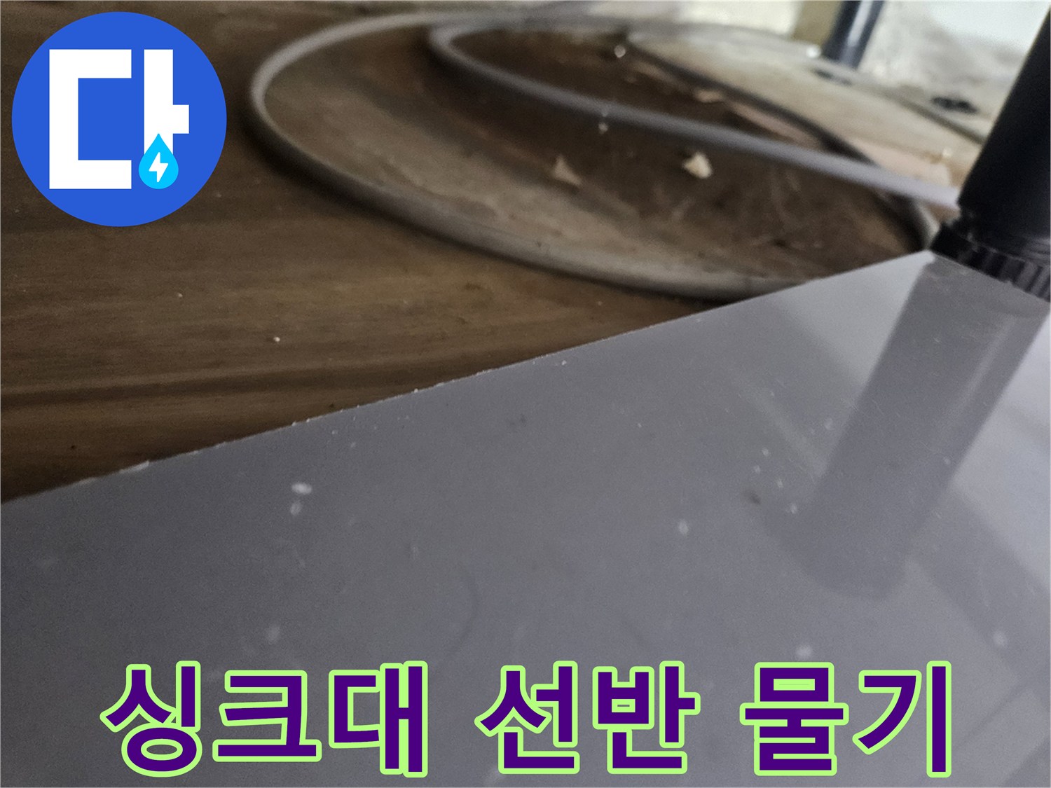 싱크대-아래-목재-선반에-맺힌-물기를-통해-누수-진행-상황을-파악하는-모습