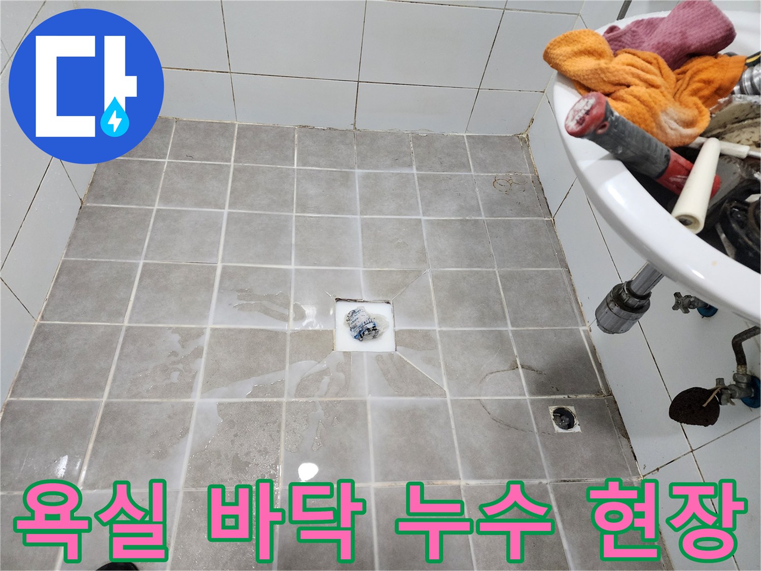 욕실 바닥 타일 위에-물이 고여-누수 문제가-발생했음을 보여주는-현장 사진입니다