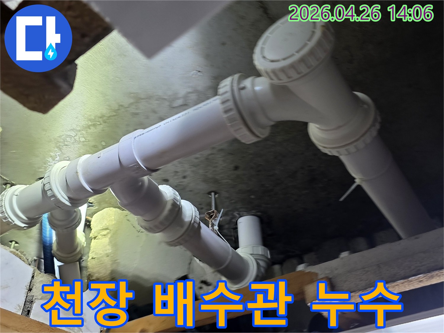 아파트 천장 아래의 배수관에서-누수가 발생하여 주변이 젖어있는-긴급 수리 현장의 모습입니다.