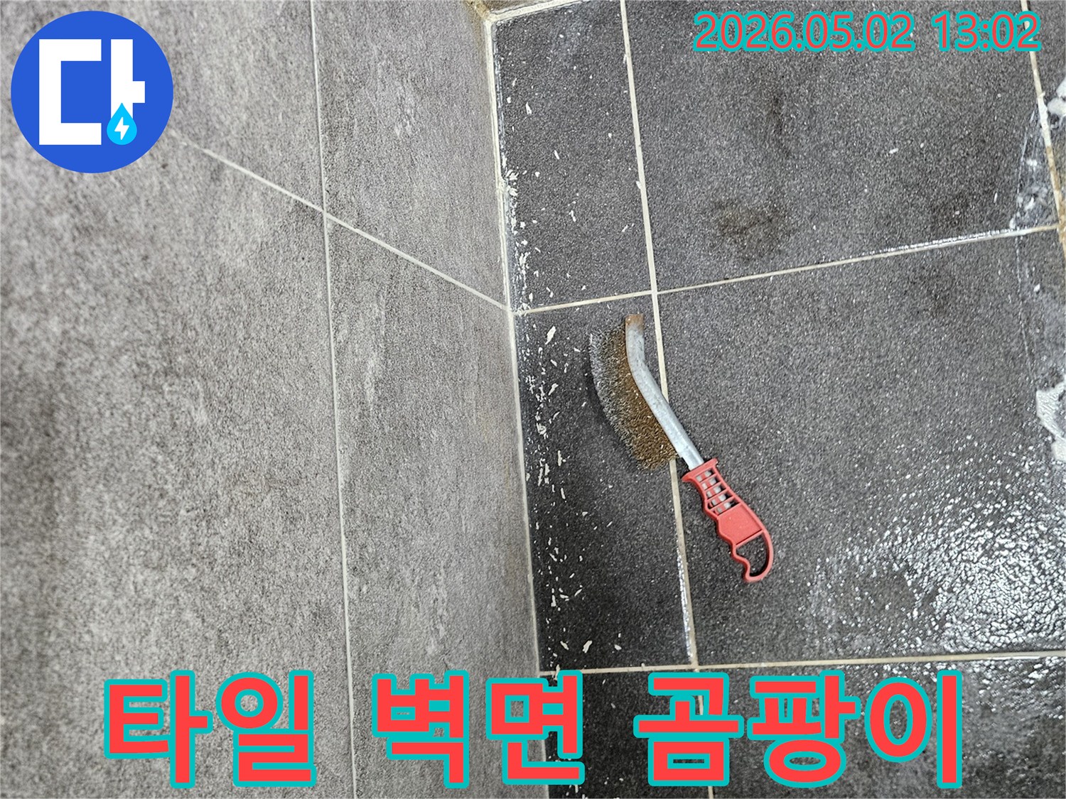누수로 인해 습해진 타일 벽면의 곰팡이를-제거하기 위해 사용되는-와이어 브러시의 모습