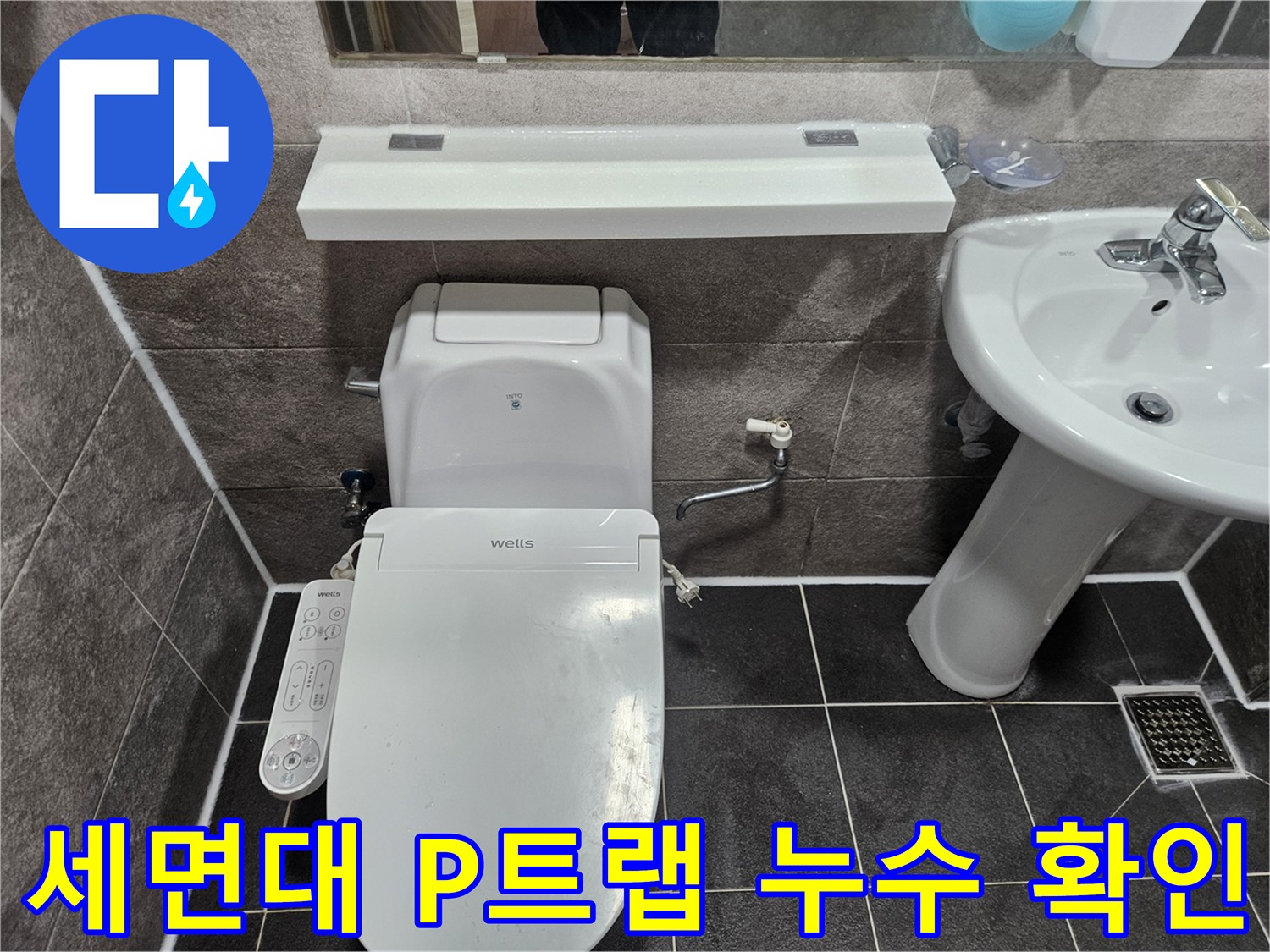안양 만안구 청호아파트 화장실에서-세면대 아래 P트랩 연결부의 누수 여부를 엔지니어가 점검하고 있습니다