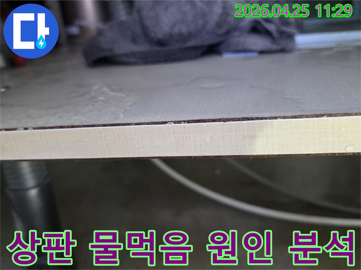 주방-싱크대-상판에-물이-스며들어-생긴-얼룩과-변형을-보여주는-이미지