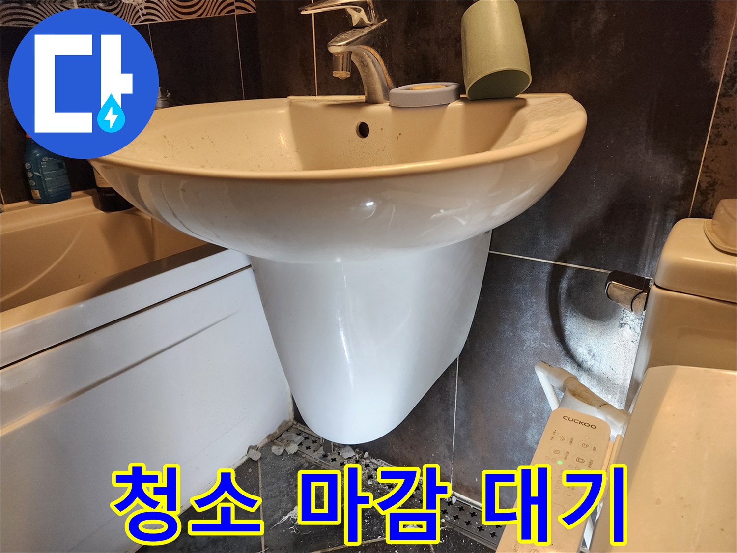 세면대-누수-수리-작업이-완료된-후-바닥에-남은-공사-잔해물을-청소하고-마감-작업을-대기하는-현장-사진입니다.