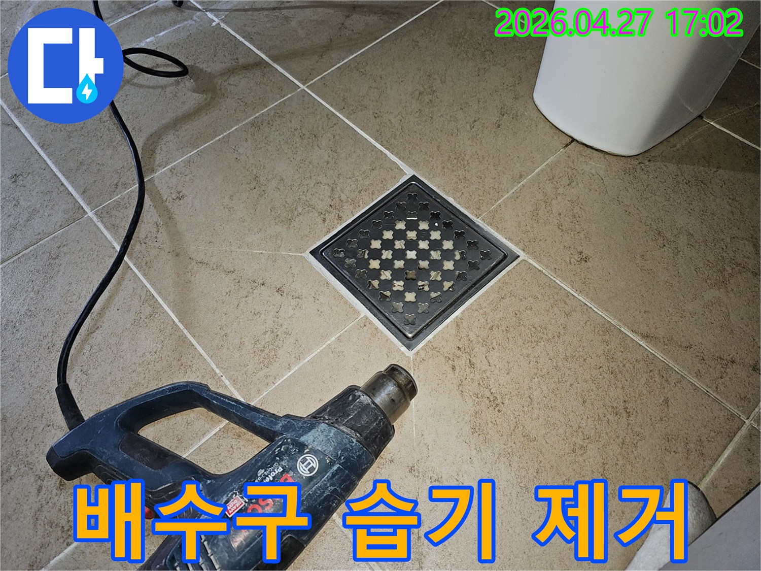 누수 수리 후-엔지니어가-히팅건으로-배수구 주변의-습기를-집중적으로-건조하는 모습입니다.