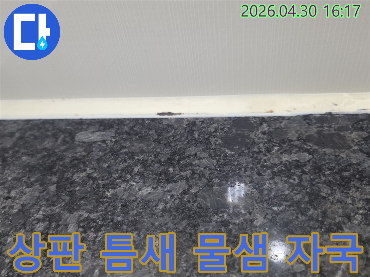 싱크대 상판과 벽면 사이의 틈새에서 발견된 물샘 자국은 누수의 명확한 증거입니다.