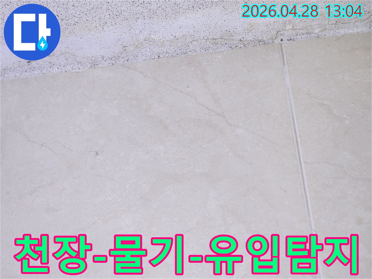 이 이미지는 주택 천장과 타일 바닥 경계에서 발견된 물기-유입 흔적을 보여주며- 전문 누수-엔지니어가 누수-원인을 탐지하고 있습니다.