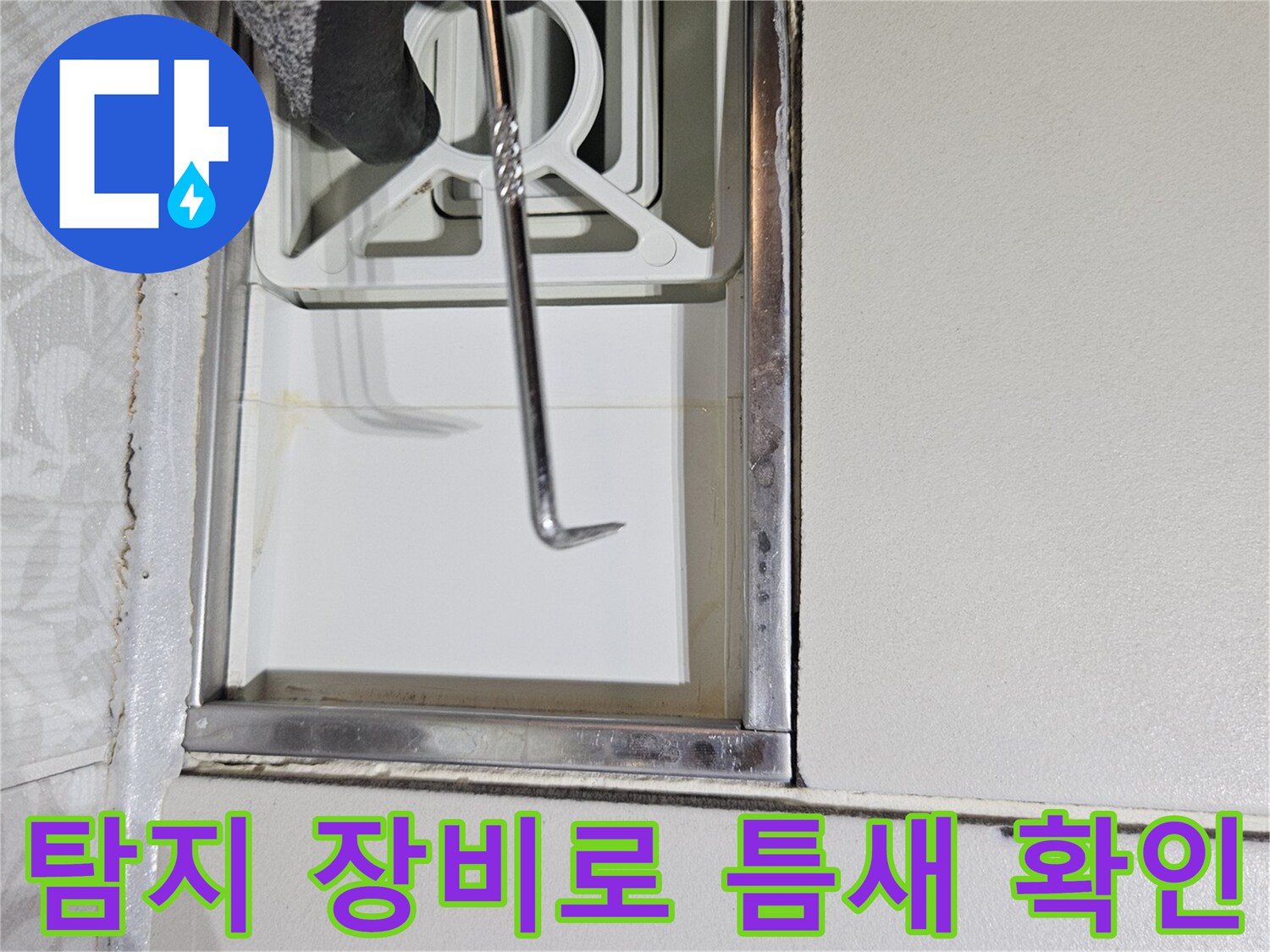 전문 누수 탐지사가-특수 제작된 도구로-벽면 하단부의-작은 틈새를-세밀하게-조사하는 모습입니다