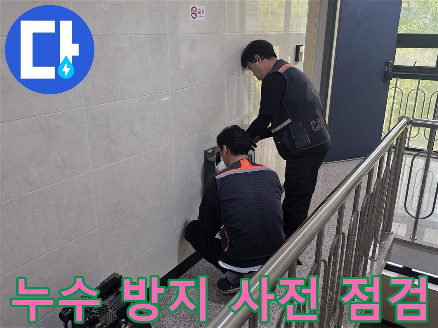 두 명의 전문 기술자가 건물 벽면의 누수 의심 지점을 정밀하게 탐지하며 누수 방지를 위한 사전 점검을 하고 있습니다-안전한 주거 환경을 위한 예방 활동입니다.