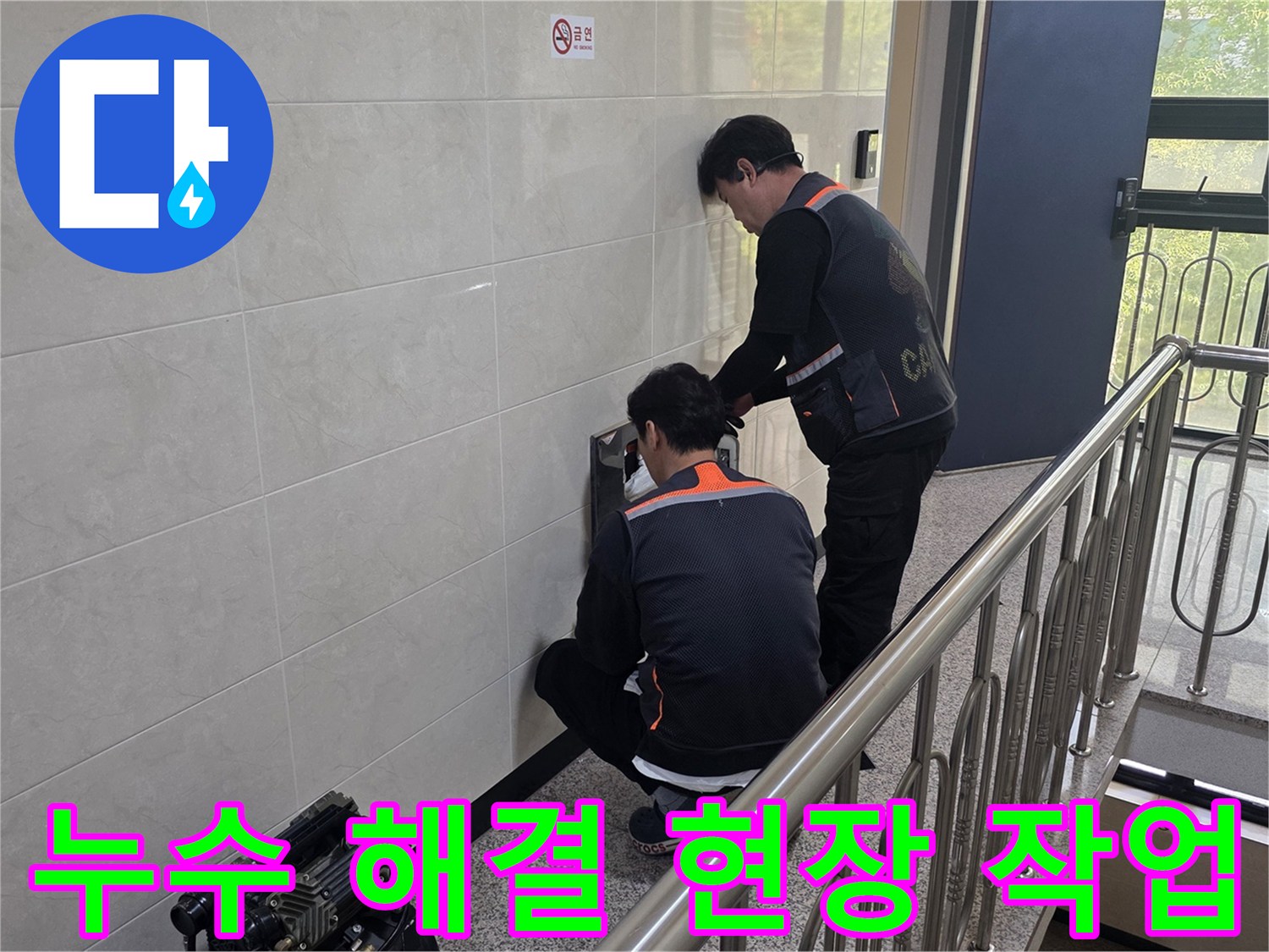 두 명의 전문 기술자가 건물 벽면의 누수 의심 지점을 정밀하게 탐지하며 신속하고 확실한 문제 해결을 위한 준비를 하고 있습니다.