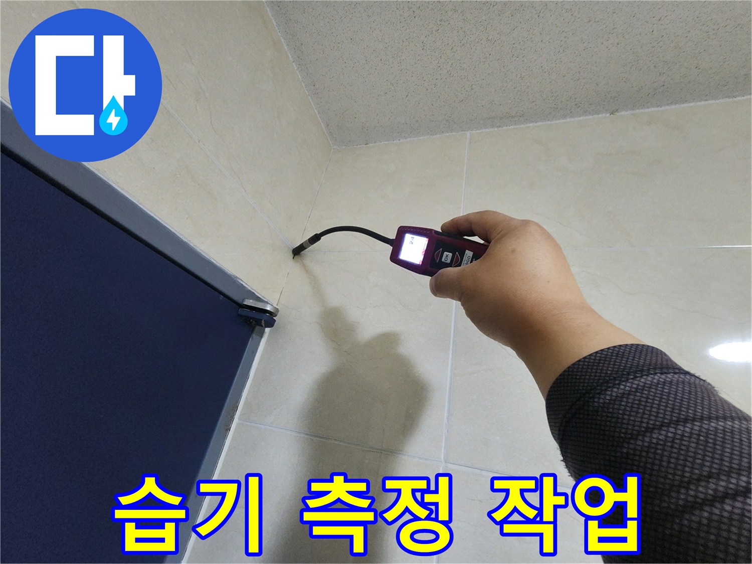 전문 누수 엔지니어가-타일 벽면 모서리의-숨겨진 습기를-정밀하게 측정하여-누수 여부를 확인하고 있습니다.