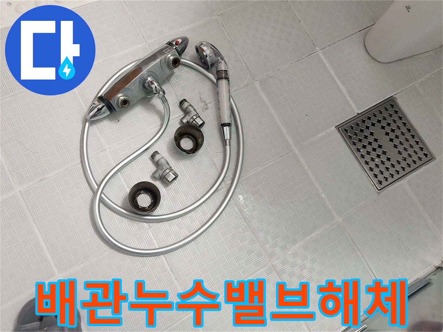 욕실 바닥에 놓인 분리된 샤워기 밸브 부품들-배관 누수 점검 및 교체를 위한 작업