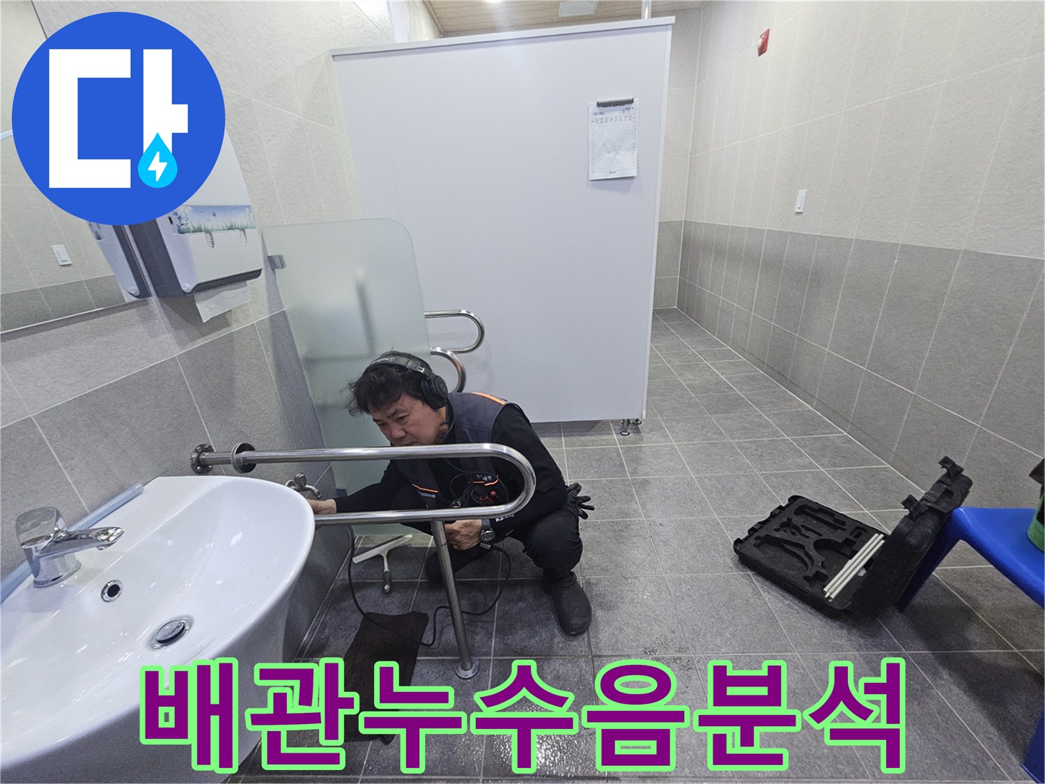 누수 전문 엔지니어가-청음식 탐지기로-욕실 배관의 누수음을 분석하고 있습니다.