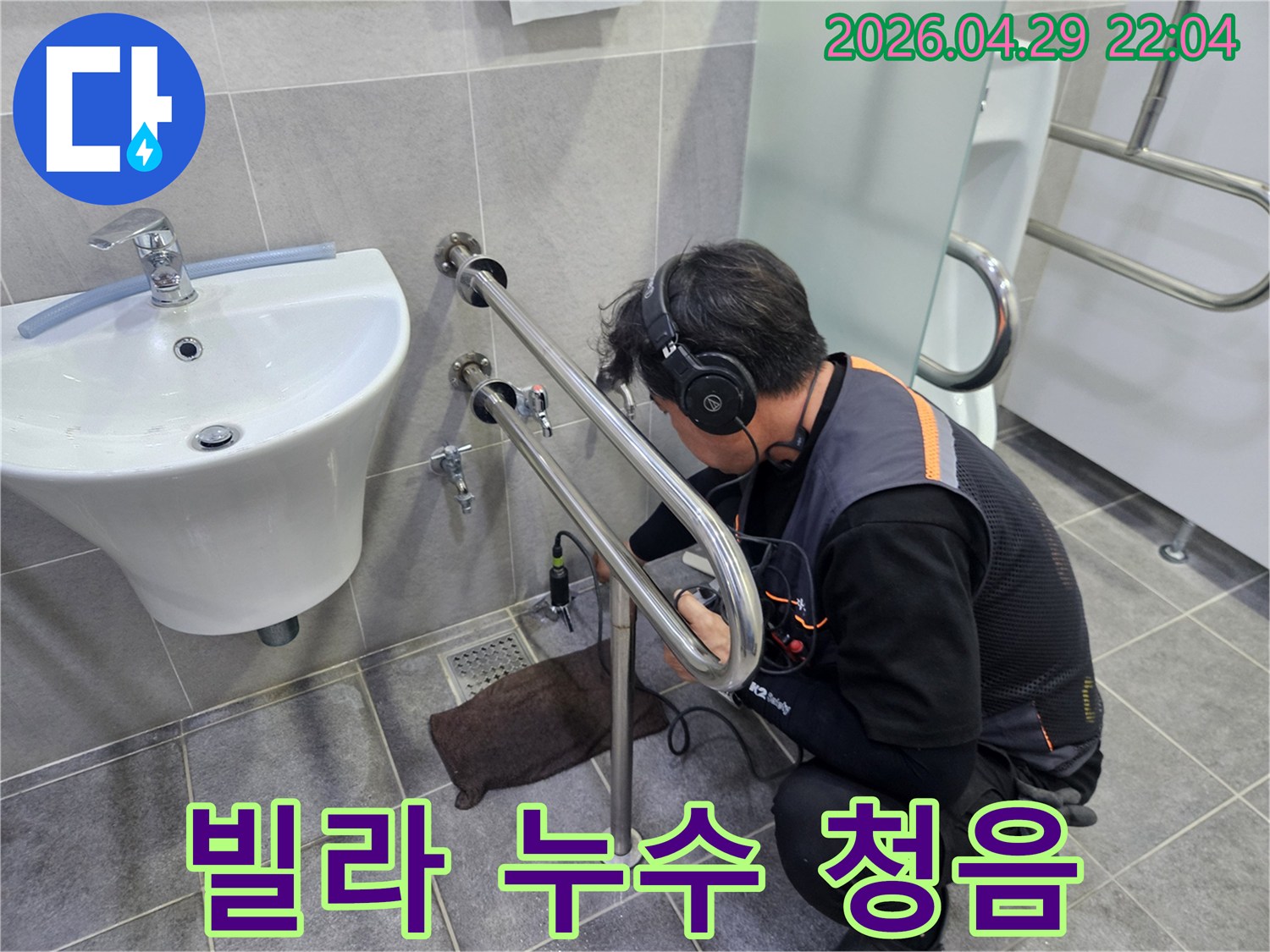 누수 탐지 전문가가-청음식 장비로-빌라 화장실 배관의-미세한 누수음을-정밀하게 듣는 모습