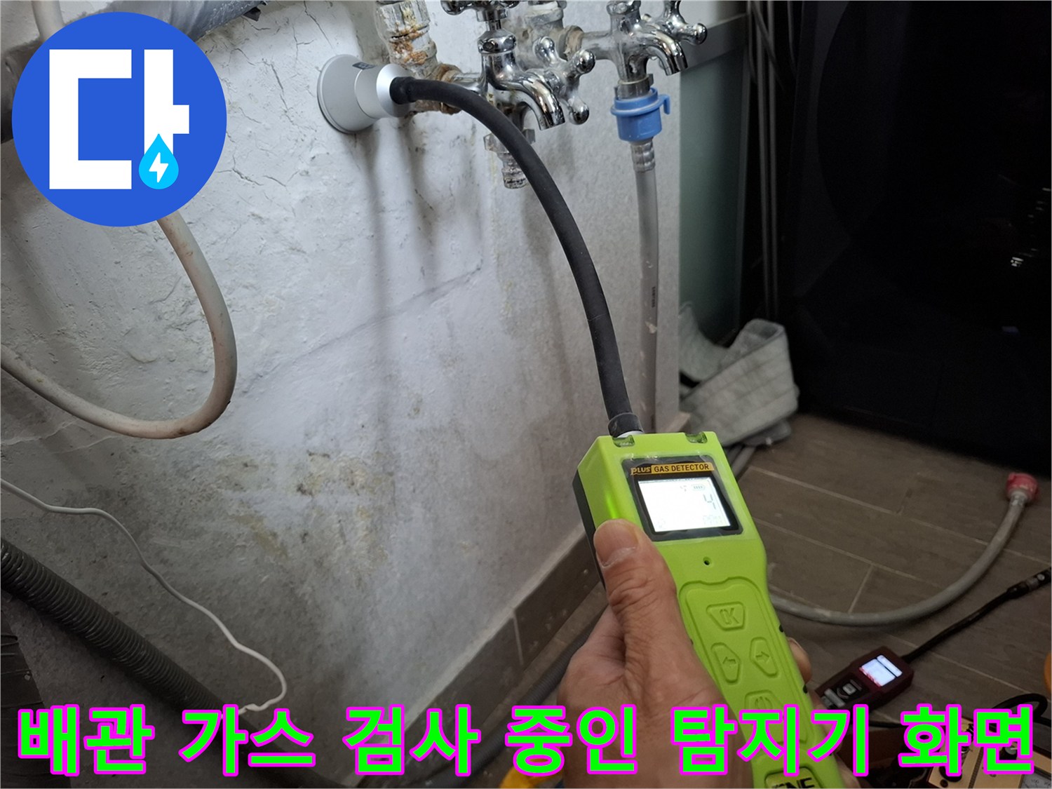 수도 배관의 누수 여부를 확인하기 위해 가스 탐지기를 벽면 근처에 대고 있습니다.