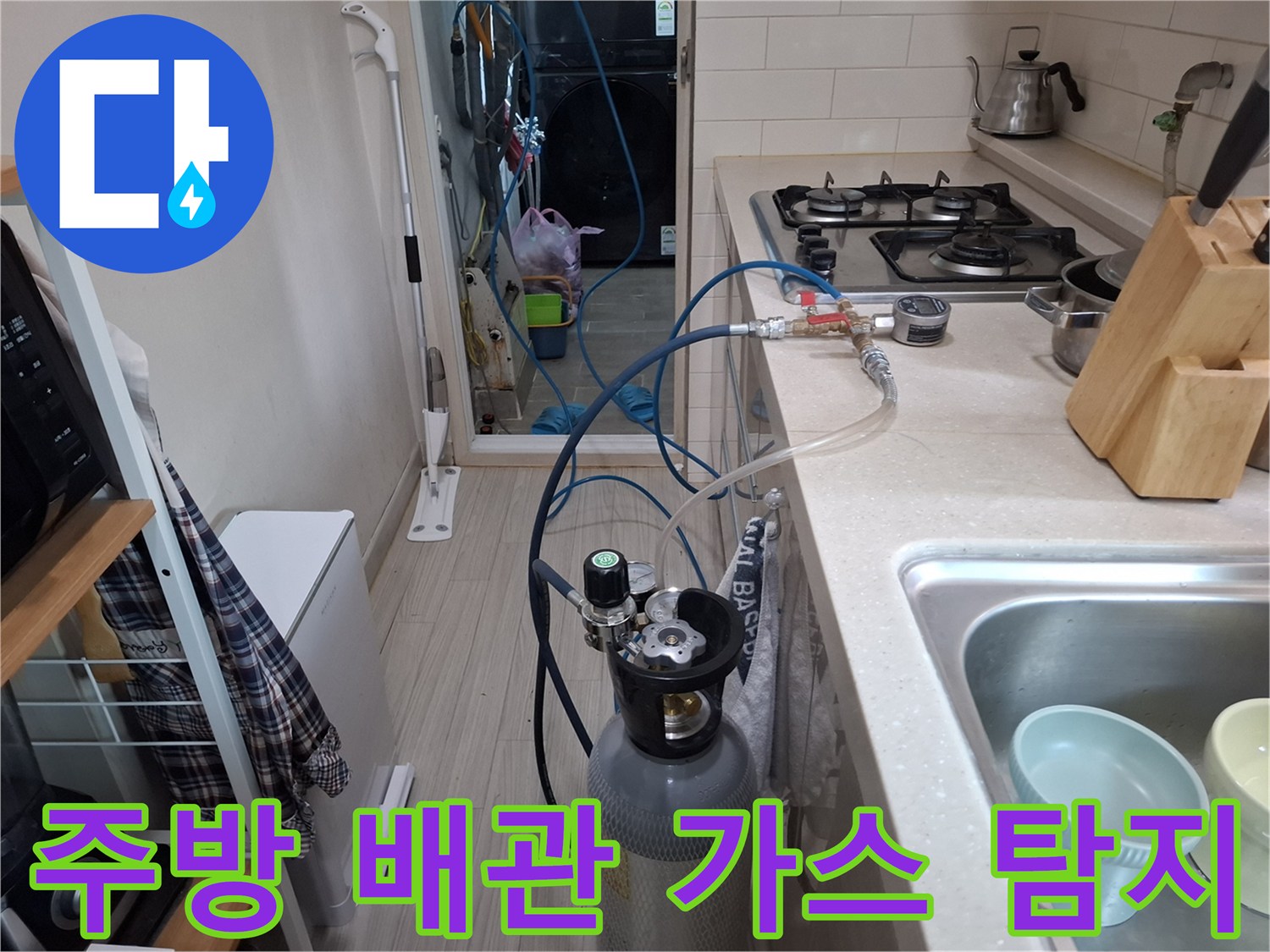 싱크대 하부 배관 주변에 설치된 가스 탐지용 레귤레이터와 호스의 모습입니다.