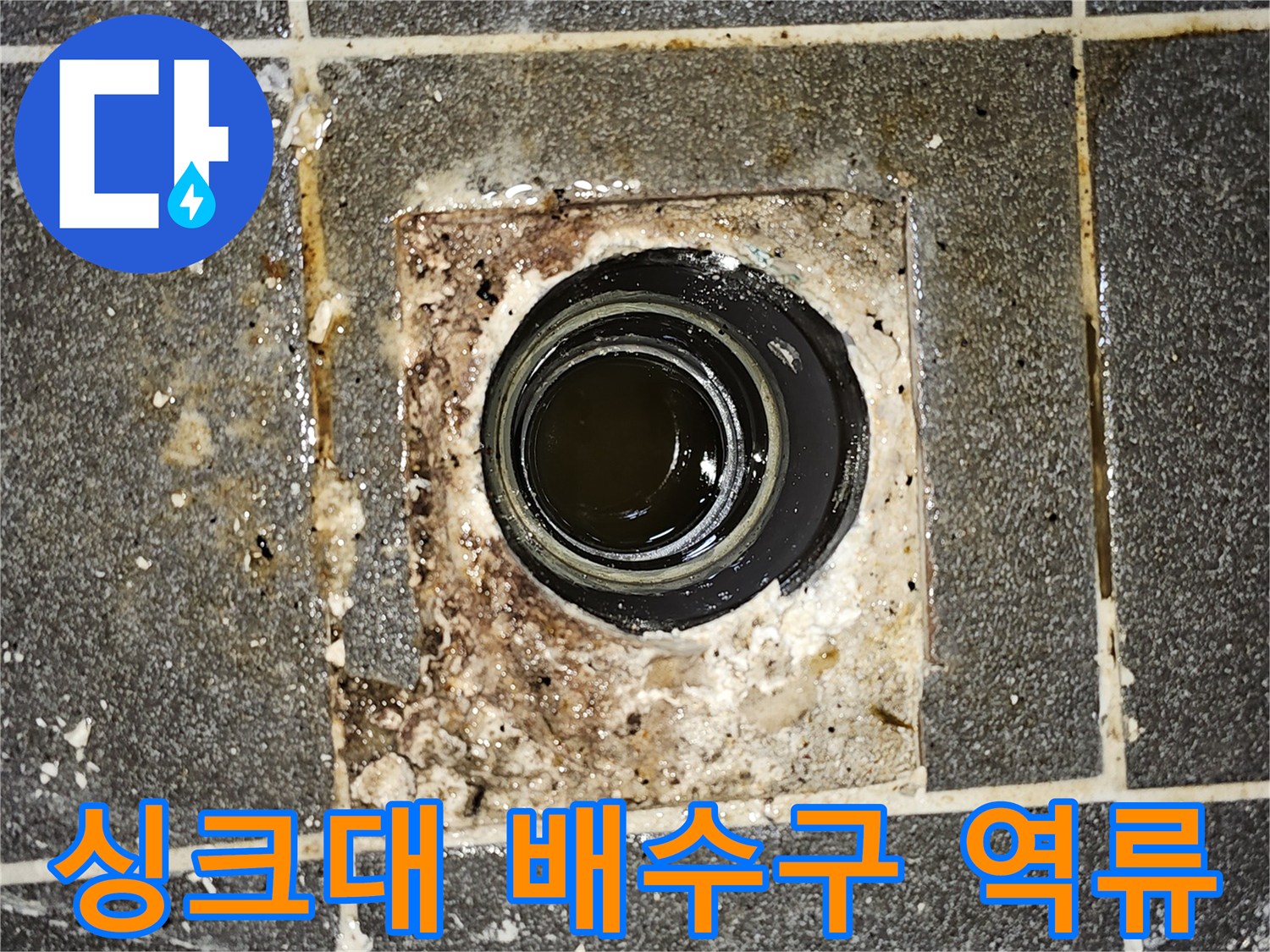 싱크대 배수구에서-오수가 역류하여 바닥에 고여있는-심각한 배관 막힘 현장을 보여주는 사진입니다.