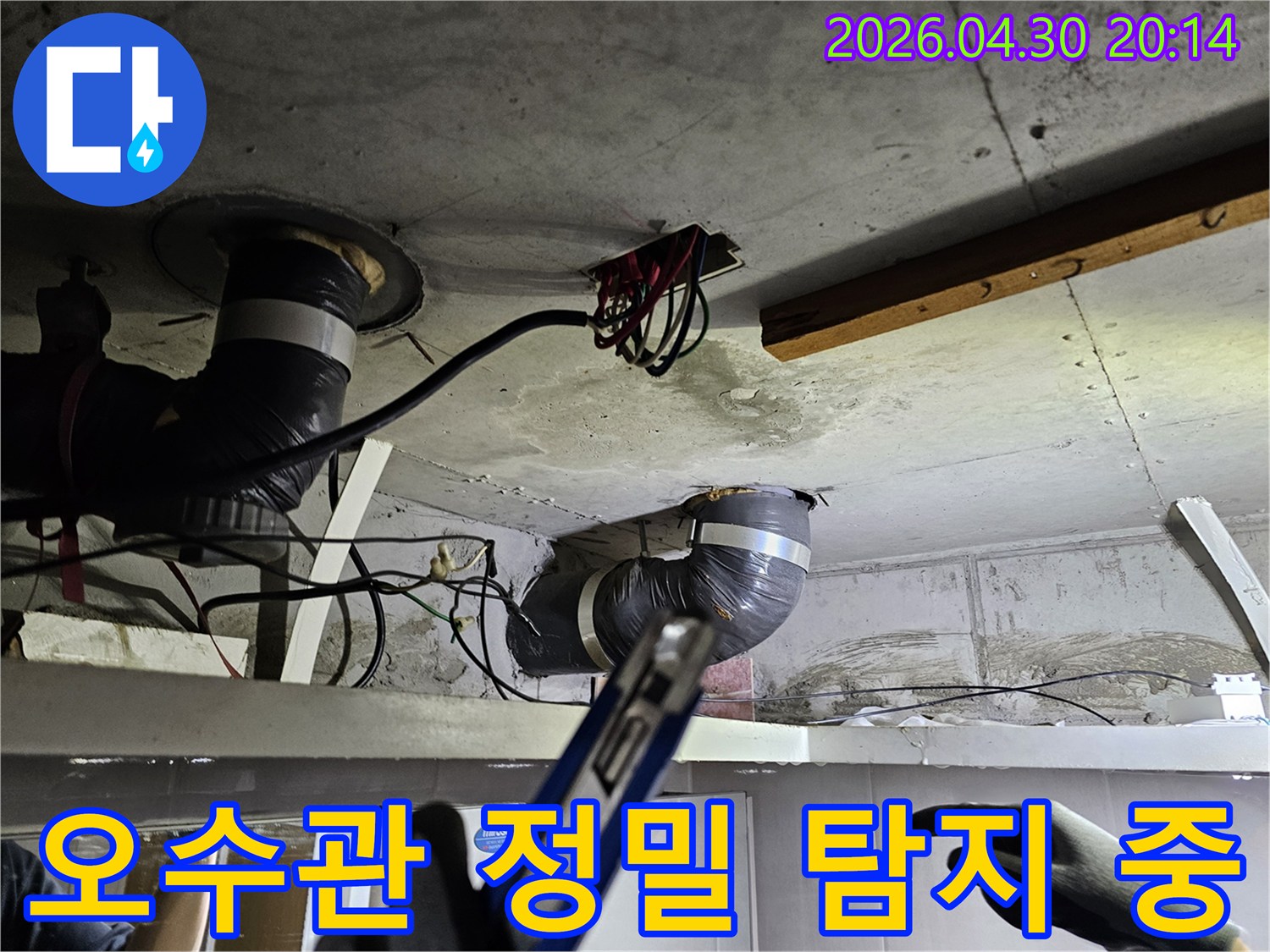 천장 배관의-복잡한 구조 속에서-오수관의 문제점을-정밀하게 탐지하는-엔지니어의 모습입니다.