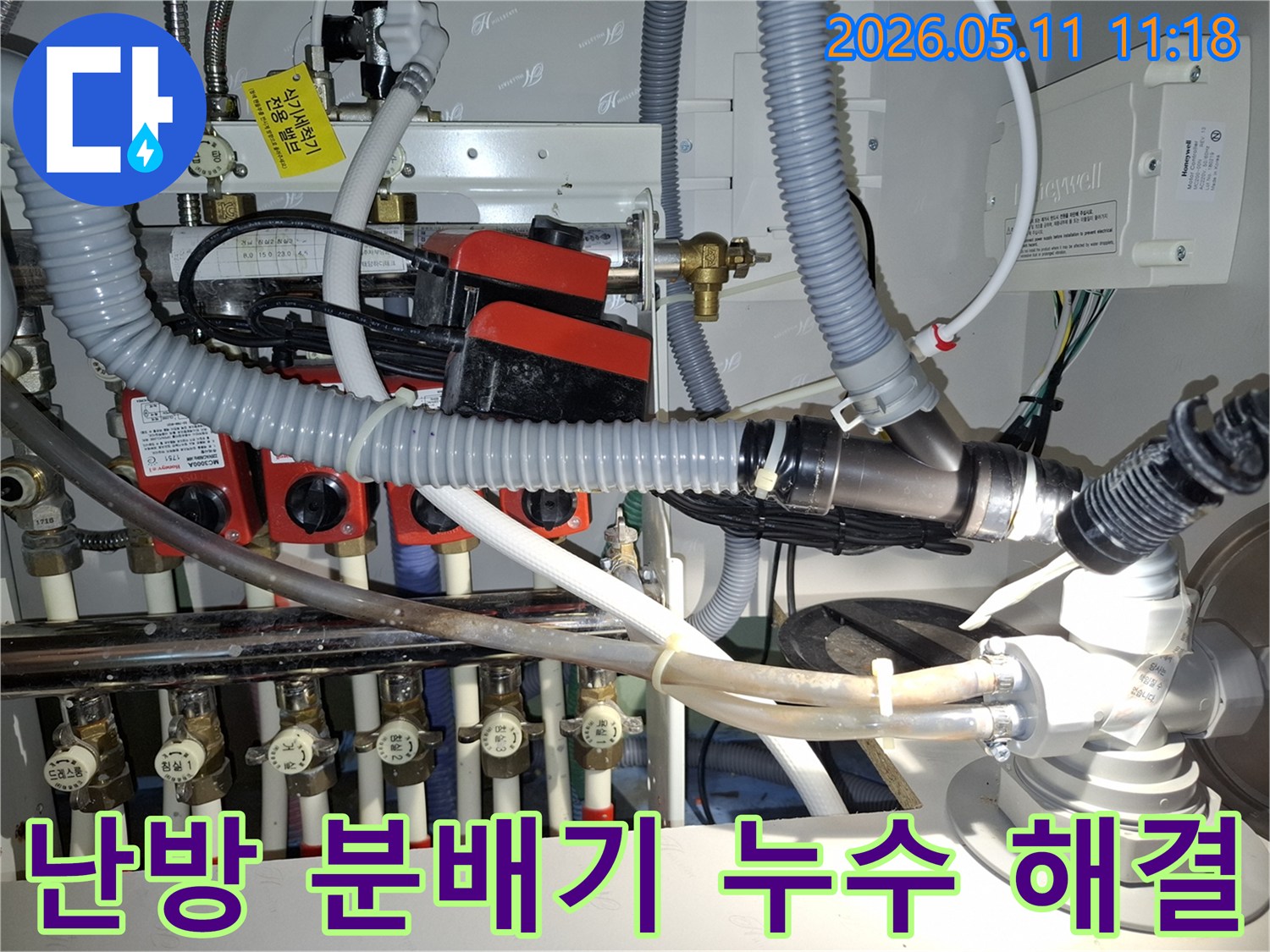 난방 분배기와 연결된 여러 배관-밸브-그리고 순환 펌프가 보이는 사진으로-누수 문제 해결을 위한 전문가의 점검 현장입니다.